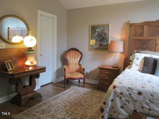 bedroom featuring wood finished floors, baseboards, and vaulted ceiling