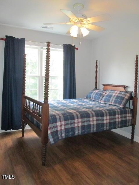 bedroom with wood finished floors, visible vents, and ceiling fan