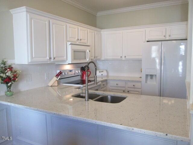 kitchen featuring light stone counters, white appliances, white cabinets, and crown molding