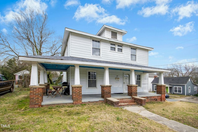 american foursquare style home with a porch and a front yard