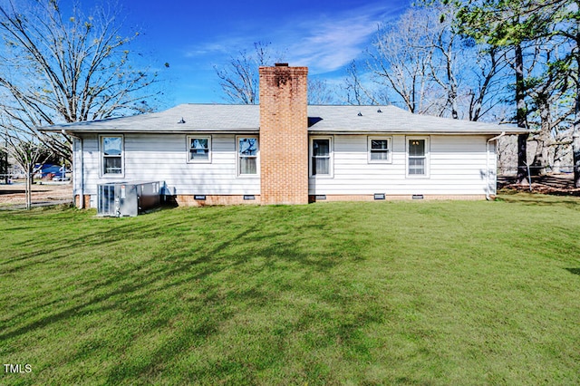 rear view of property featuring crawl space, a lawn, a chimney, and central AC