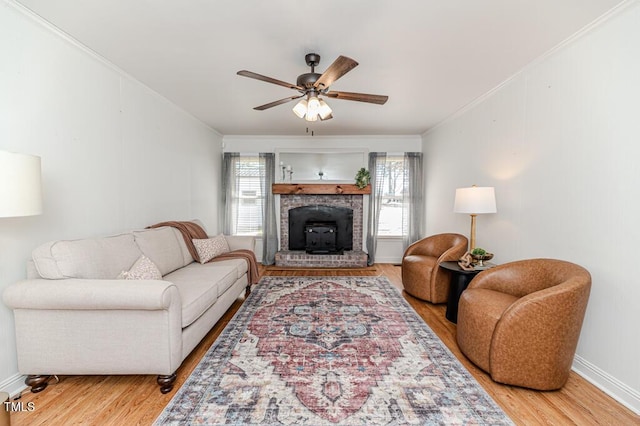 living area featuring baseboards, a ceiling fan, wood finished floors, and crown molding