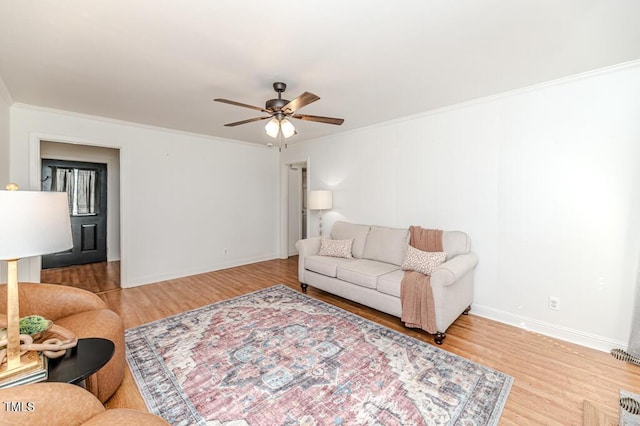 living room with crown molding, light wood-type flooring, and ceiling fan