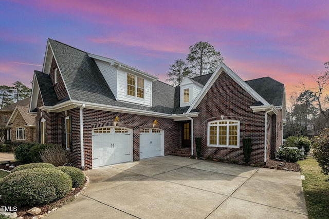 view of front of property with brick siding, an attached garage, driveway, and roof with shingles