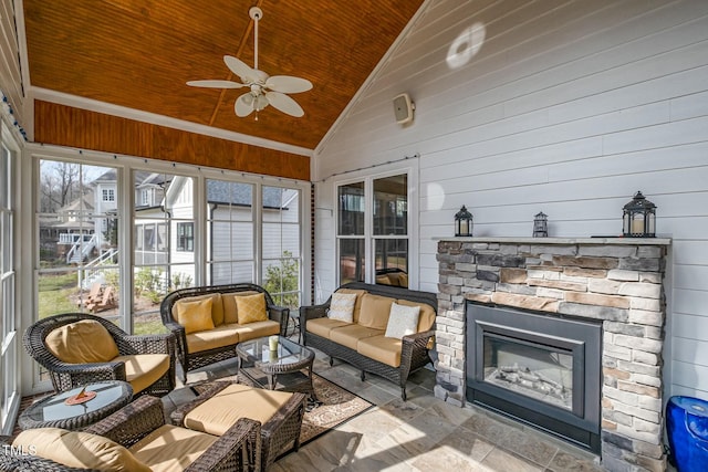 sunroom with a glass covered fireplace, lofted ceiling, wooden ceiling, and a ceiling fan