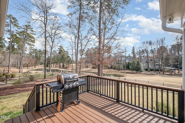 wooden deck featuring area for grilling, fence, and a lawn