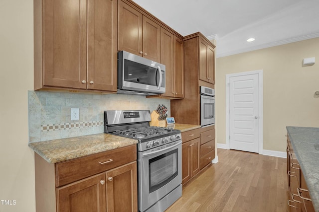 kitchen featuring brown cabinets, stainless steel appliances, light wood-style floors, decorative backsplash, and baseboards