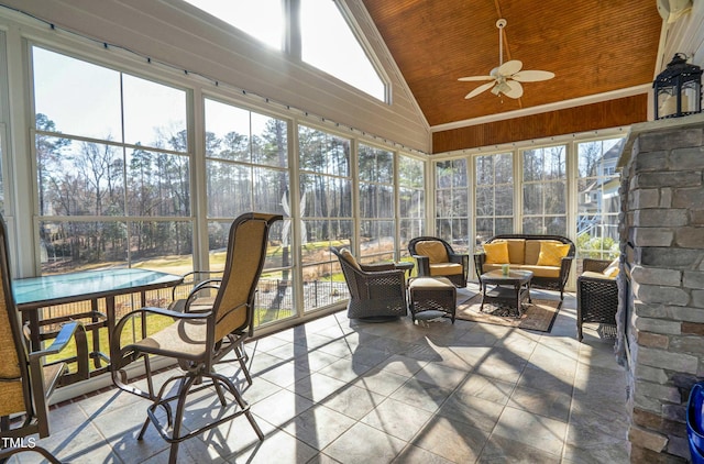 sunroom / solarium with wood ceiling, a ceiling fan, and vaulted ceiling