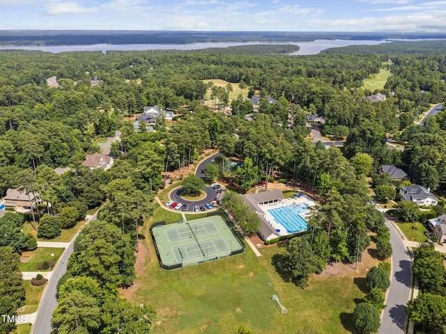 drone / aerial view with a wooded view and a water view