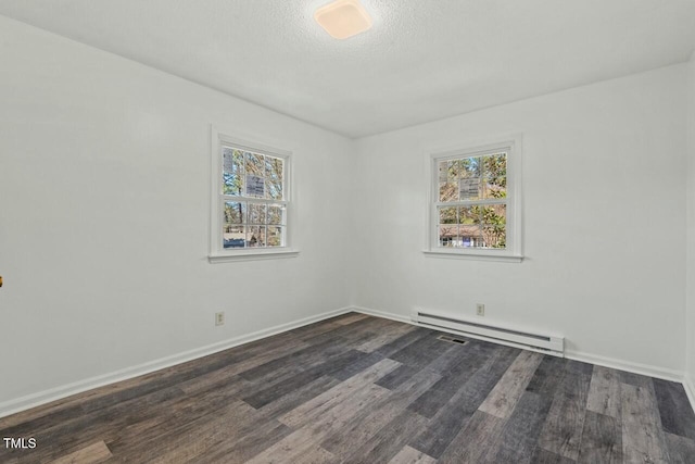 empty room featuring a baseboard radiator, dark wood finished floors, a textured ceiling, and baseboards