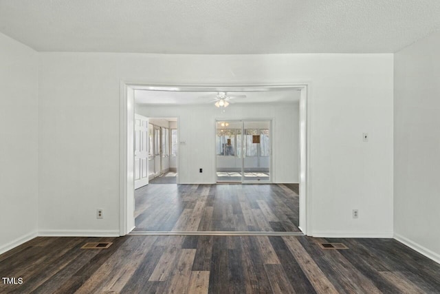 empty room featuring baseboards, visible vents, ceiling fan, and wood finished floors