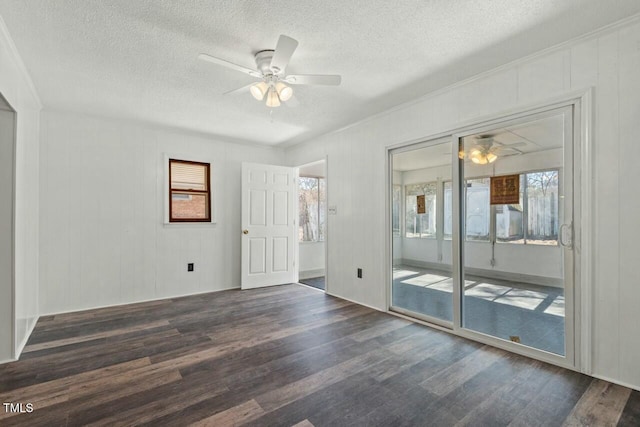 empty room with a textured ceiling, a ceiling fan, and wood finished floors