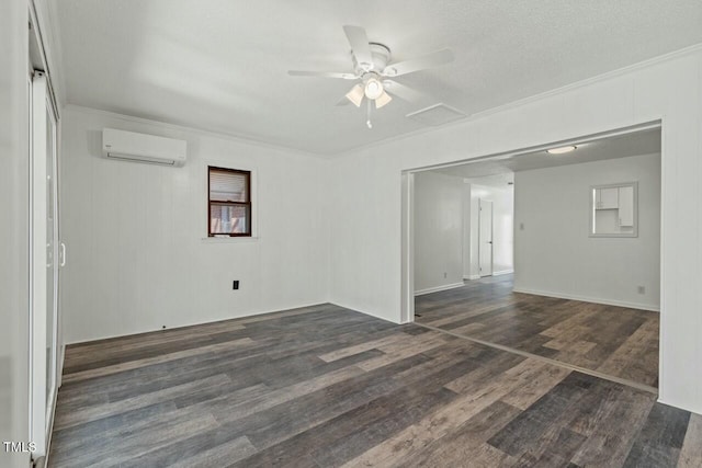 spare room featuring a ceiling fan, an AC wall unit, crown molding, and dark wood finished floors