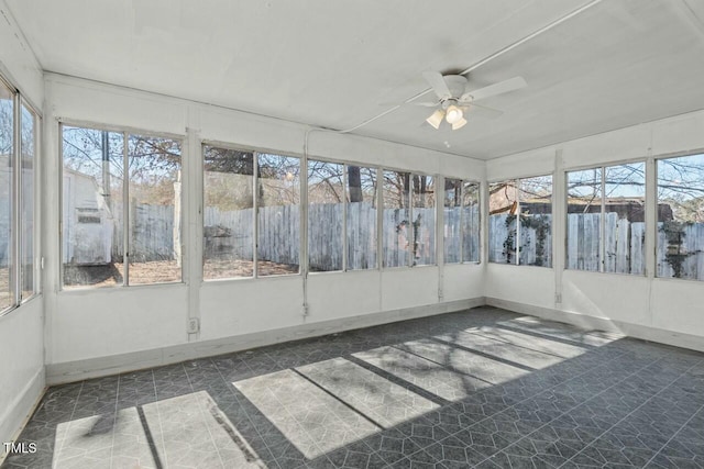 unfurnished sunroom featuring a wealth of natural light and ceiling fan