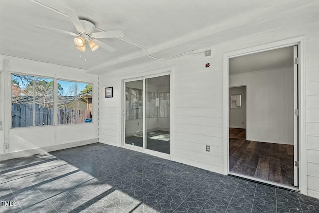 unfurnished sunroom with ceiling fan