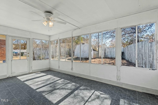 unfurnished sunroom featuring a ceiling fan