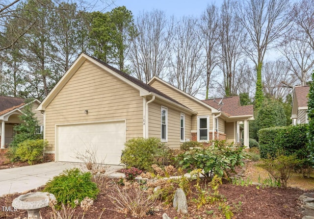 view of home's exterior featuring concrete driveway, a garage, and roof with shingles