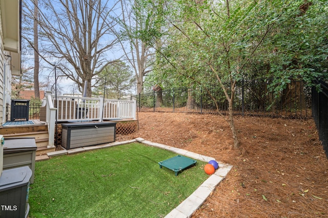 view of yard with a wooden deck, a fenced backyard, and a jacuzzi