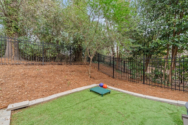 view of community featuring a yard and fence