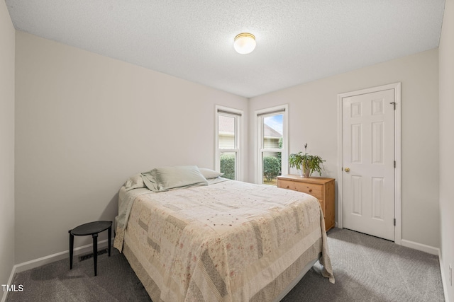 bedroom with baseboards, carpet floors, and a textured ceiling