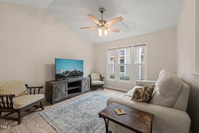 living room with lofted ceiling, a ceiling fan, baseboards, and light wood finished floors