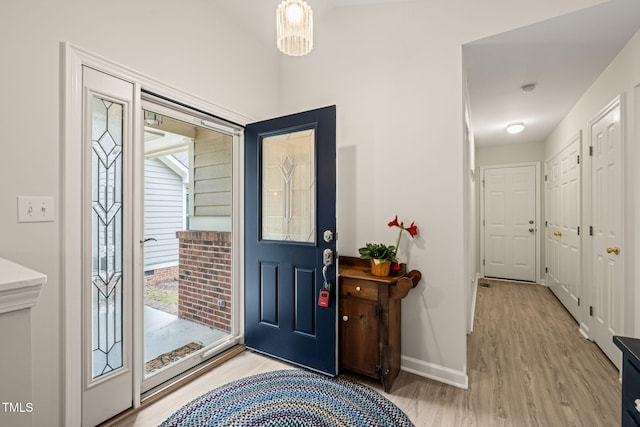 foyer entrance featuring baseboards and light wood-style floors