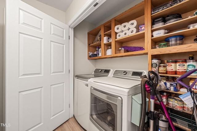 laundry area featuring laundry area, light wood-style flooring, and separate washer and dryer