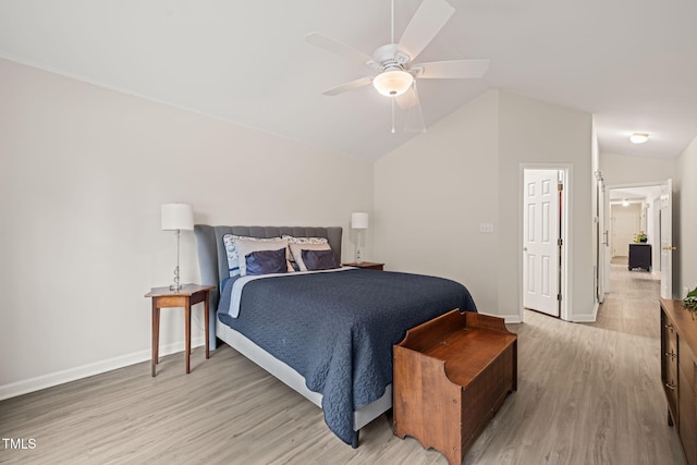 bedroom featuring baseboards, light wood-style floors, ceiling fan, and vaulted ceiling