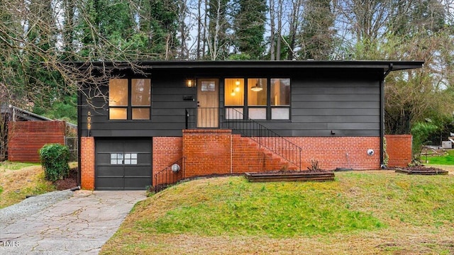 view of front facade featuring aphalt driveway, a garage, brick siding, stairway, and a front yard