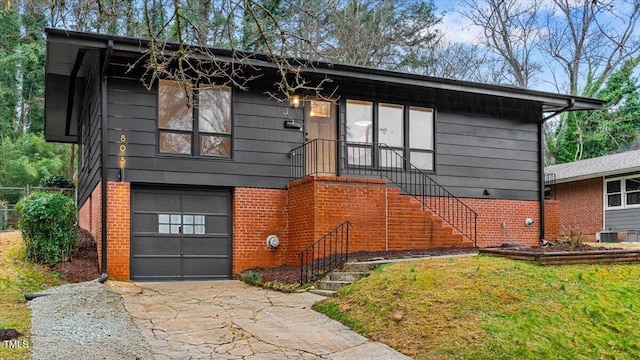 view of front of house with an attached garage, driveway, and brick siding