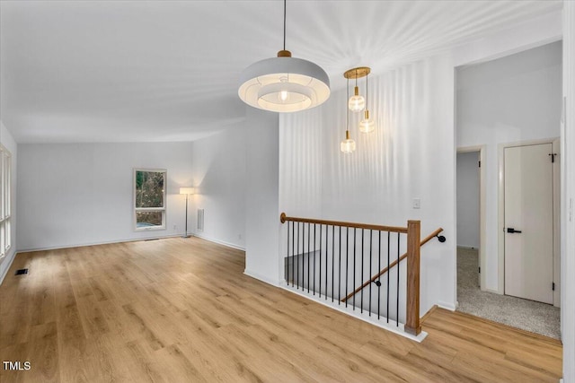 unfurnished room featuring visible vents, baseboards, and wood finished floors