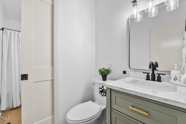 full bath featuring vanity, wood finished floors, and toilet