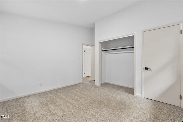 unfurnished bedroom featuring carpet, a closet, and baseboards