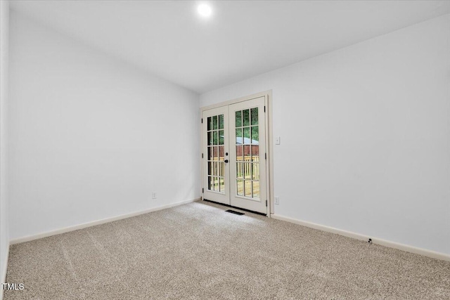 carpeted empty room with french doors, visible vents, and baseboards