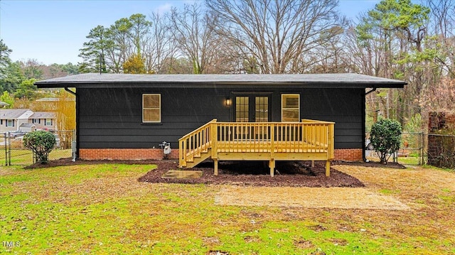 back of property featuring a gate, fence, a deck, and a yard