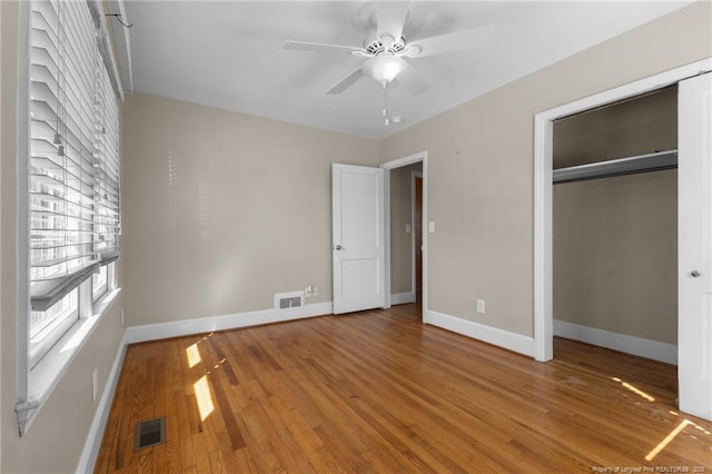 unfurnished bedroom featuring light wood-style floors, a closet, visible vents, and baseboards