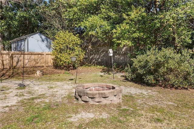 view of yard featuring an outdoor fire pit and fence