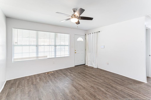 unfurnished room with visible vents, ceiling fan, and wood finished floors