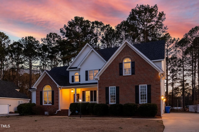 traditional-style house featuring brick siding and driveway