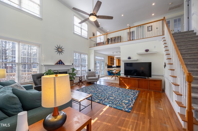 living room featuring wood finished floors, recessed lighting, stairway, a fireplace, and ceiling fan