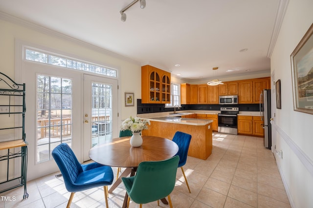 kitchen featuring brown cabinetry, appliances with stainless steel finishes, light countertops, and ornamental molding