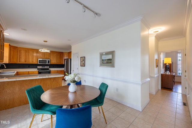 dining room featuring visible vents, rail lighting, crown molding, light tile patterned floors, and baseboards