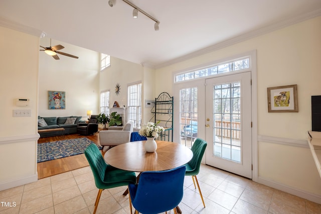 dining space with rail lighting, crown molding, light tile patterned flooring, and french doors