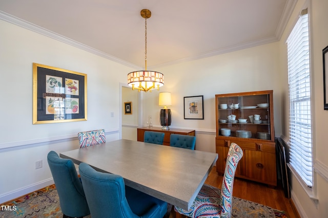 dining room with dark wood finished floors, crown molding, and baseboards