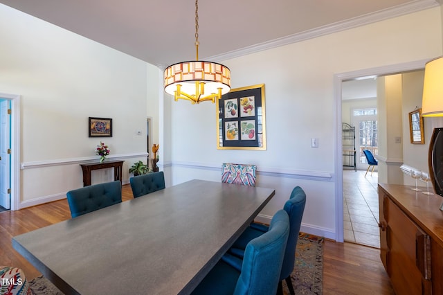 dining space with baseboards, an inviting chandelier, dark wood-style flooring, and crown molding