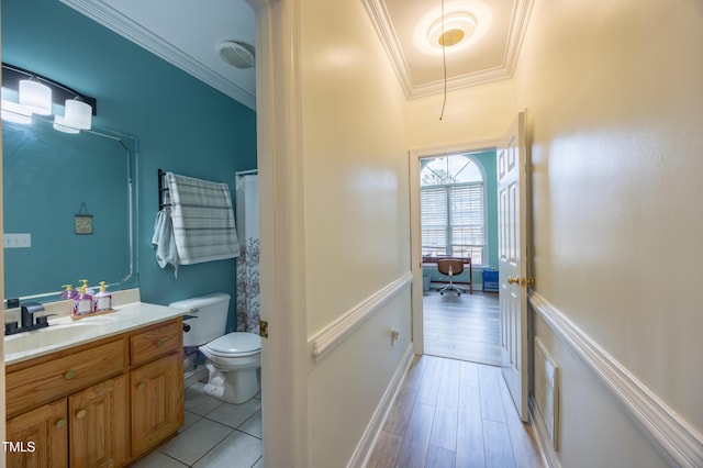 bathroom featuring visible vents, toilet, ornamental molding, wood finished floors, and vanity