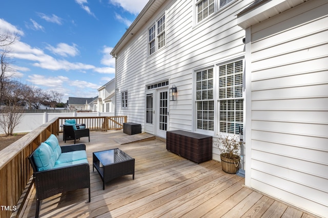 wooden deck with an outdoor living space and fence