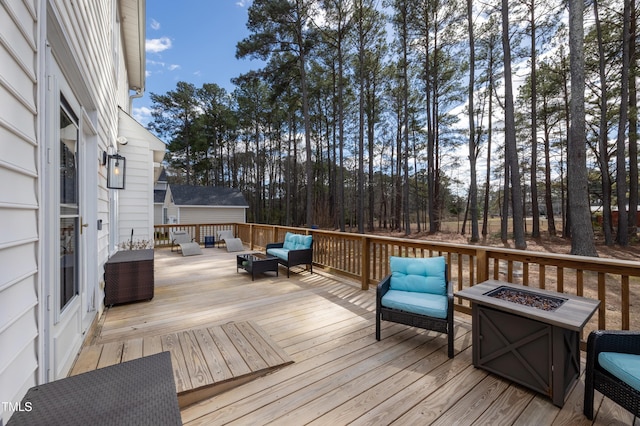 wooden terrace with an outdoor living space with a fire pit