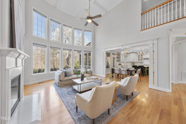 living room with light wood finished floors, baseboards, and a premium fireplace