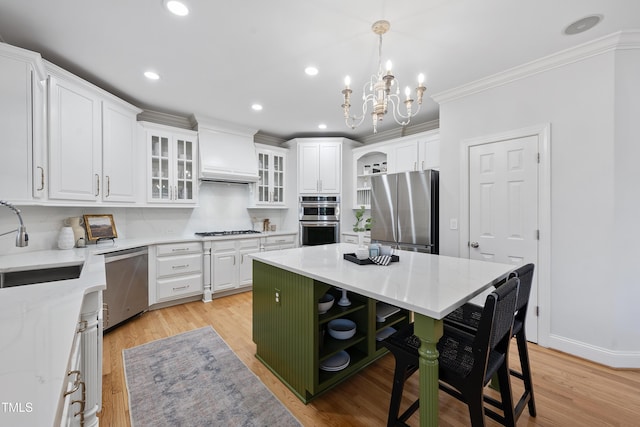 kitchen with a sink, stainless steel appliances, white cabinets, and premium range hood